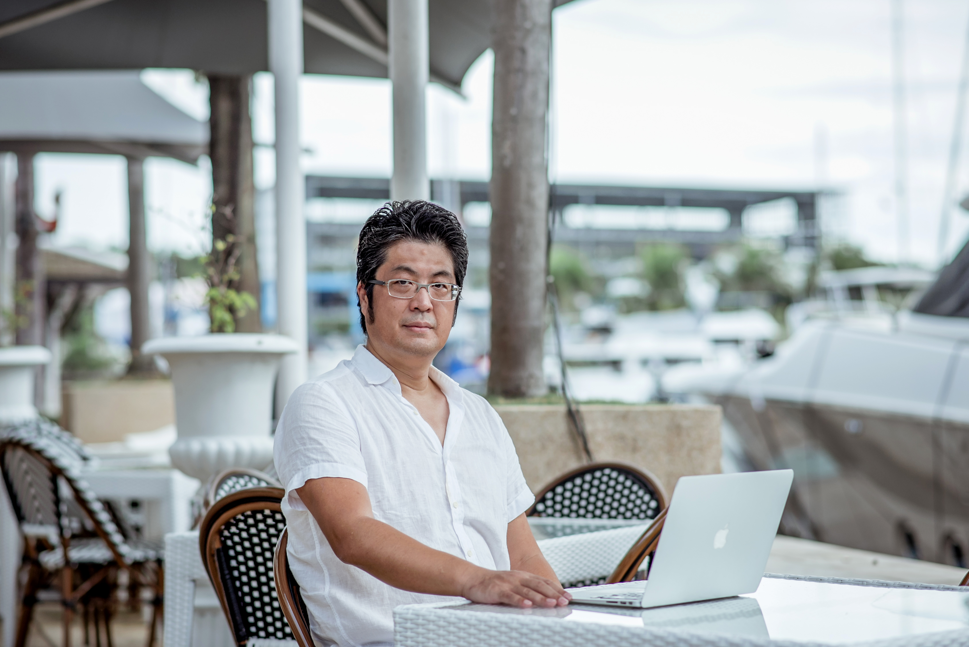 講師・池田秀樹。白い半袖シャツでノートパソコンに向かう本人写真。